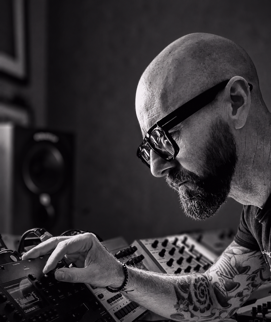 Black-and-white portrait of Adam working at the studio controls